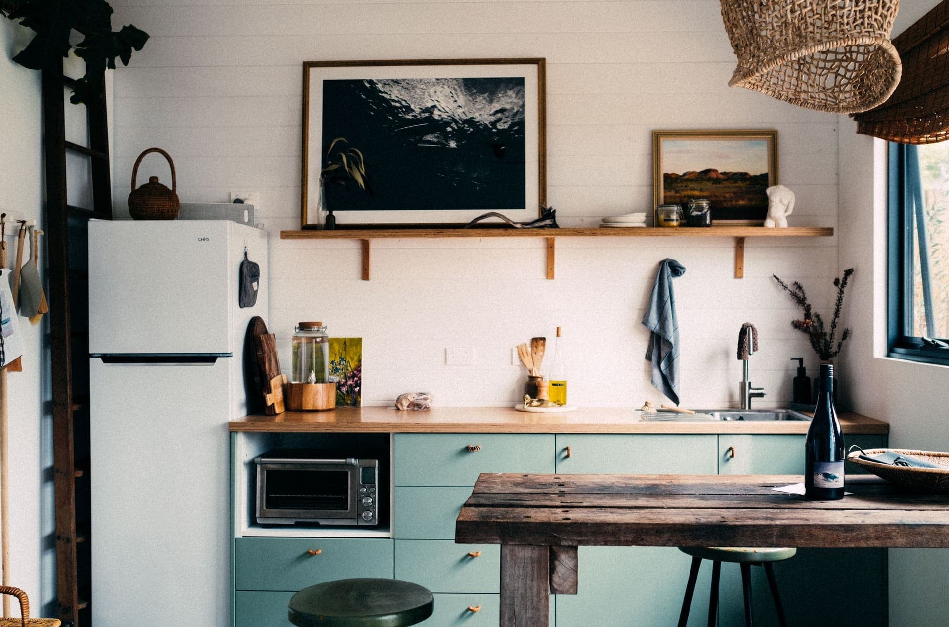 Kitchen with sage-green painted cabinets and a wooden counter